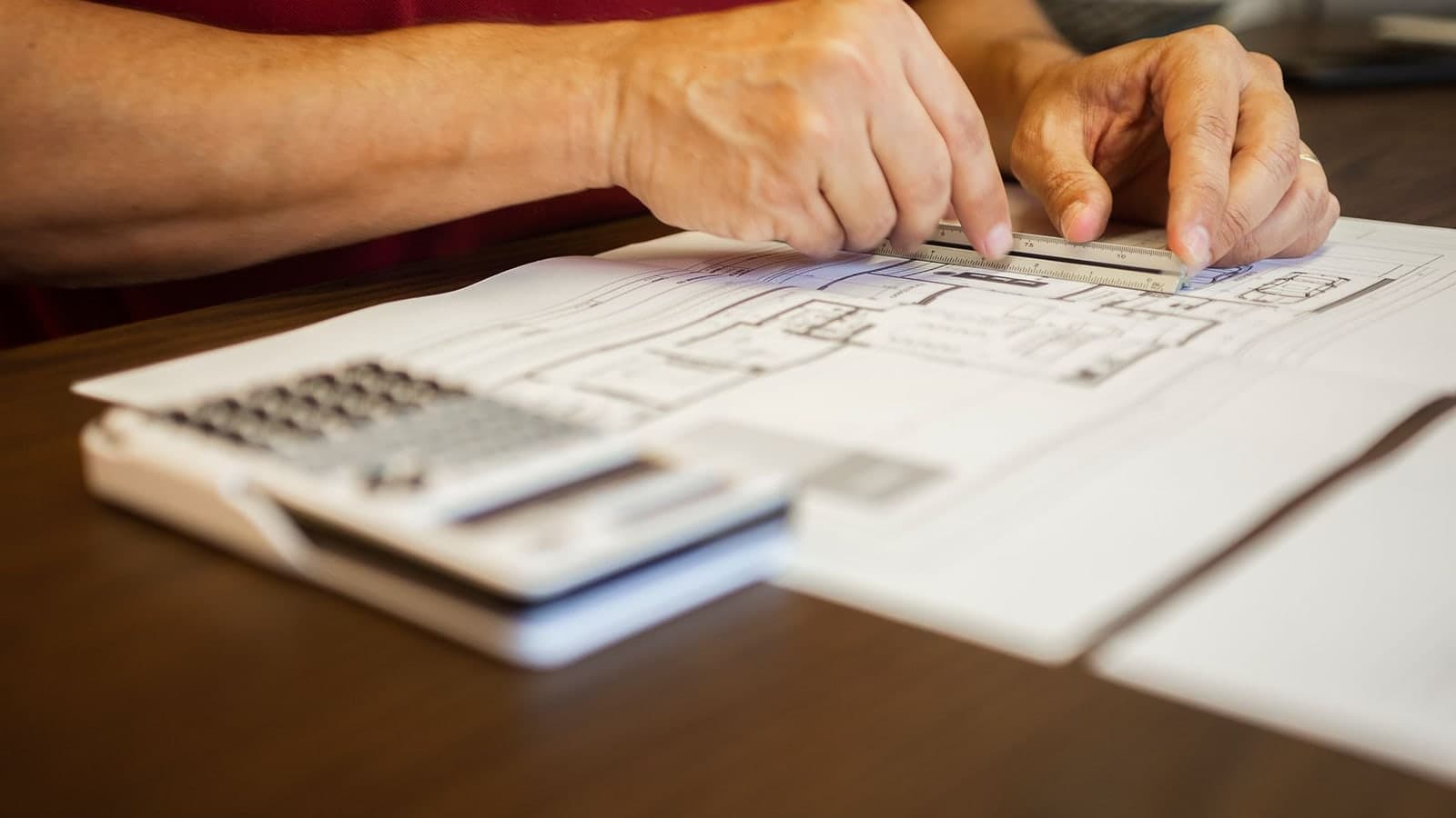 Architecte contrôlant un plan et un acte d'engagement ATTRI1 avant signature