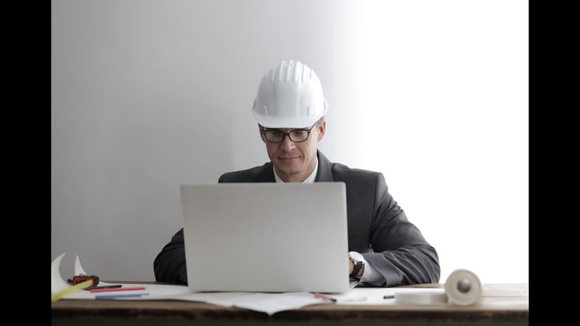 Ingénieur contrôlant une DPGF et des plans sur son ordinateur