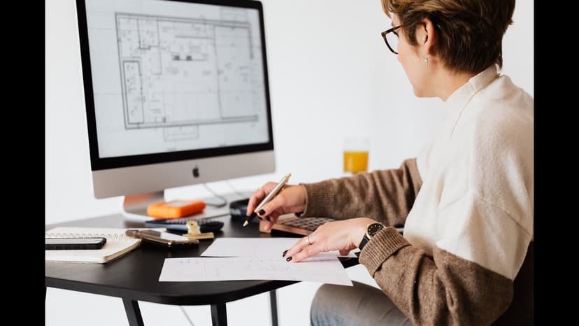 Architecte mesurant un plan PDF affiché sur un ordinateur