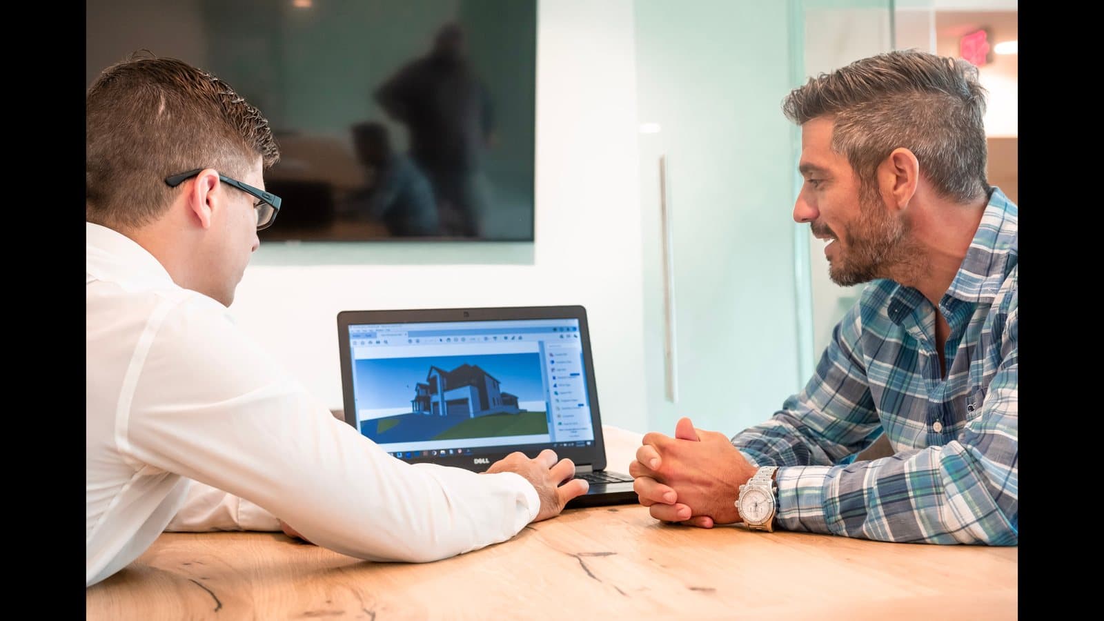 Deux architectes examinant un rendu 3D sur un ordinateur portable