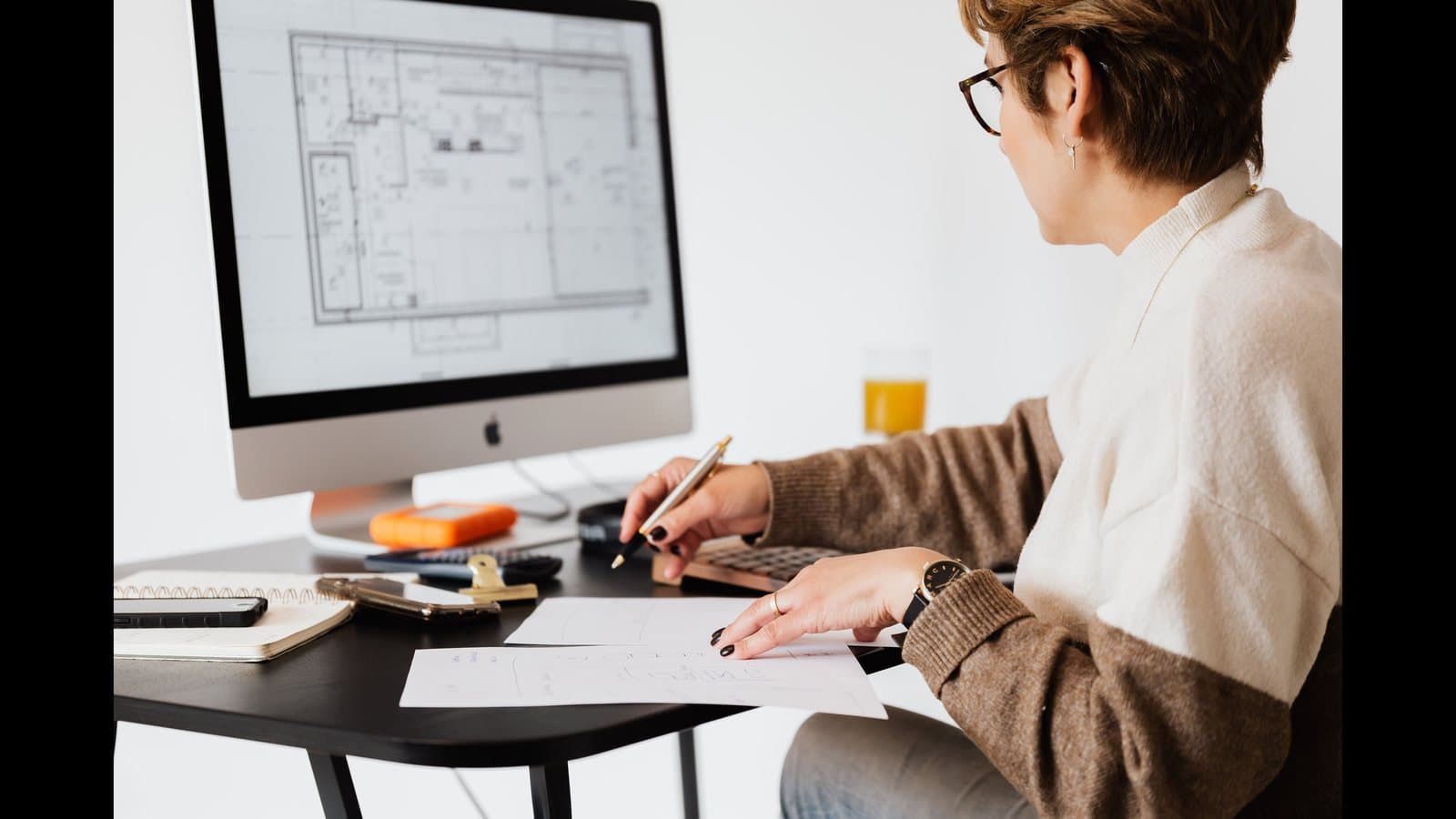 Architecte mesurant un plan PDF affiché sur un ordinateur